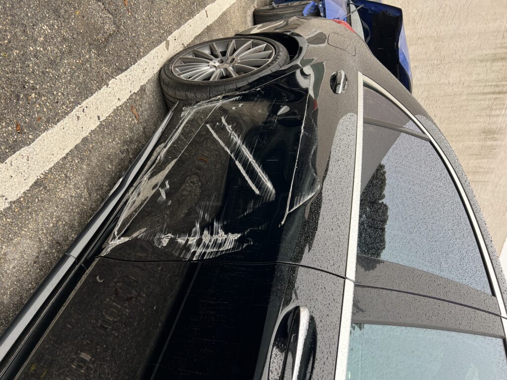 Vehicle with side collision damage showing dents and scratches before repair