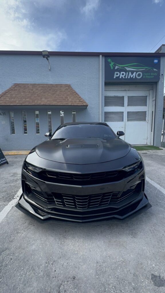 Fully restored sports car with new front bumper and flawless paint finish after collision repair at Primo Paint & Body