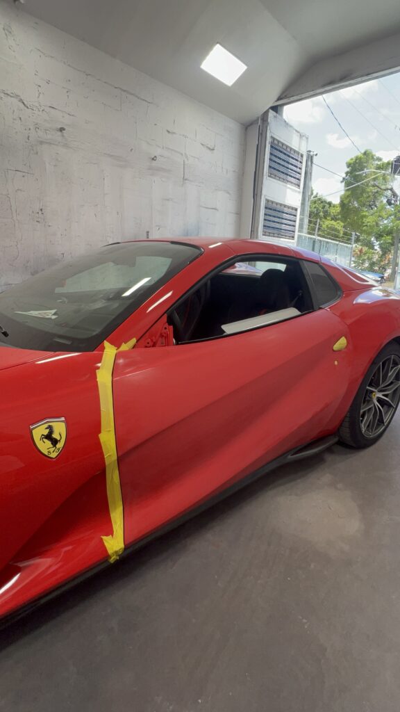 Ferrari car with collision damage showing dents and scratches before repair